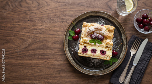 Polish sour cherry karpatka cake on a table seen from above with copy space, ad image traditional East European food
