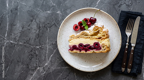 Polish sour cherry karpatka cake on a table seen from above with copy space, ad image traditional East European food