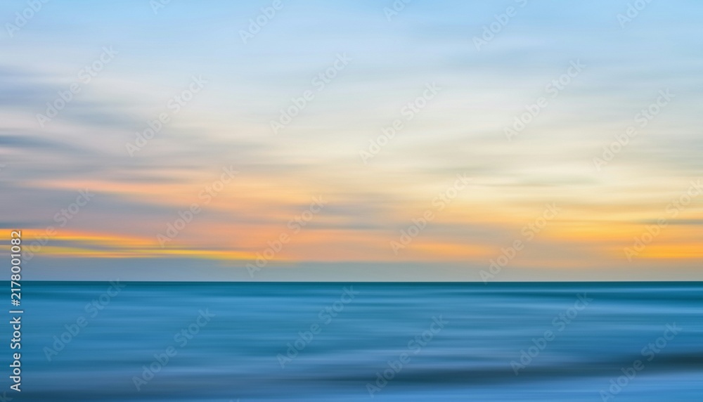 Fototapeta premium Abstract motion blur seascape with pastel sunset sky over calm ocean