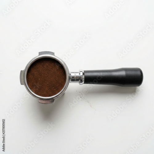 Espresso portafilter with coffee grounds isolated on white background