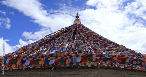 The Changqing Chunker Temple in Litang, China. Many colourful prayer flags on the mountain top beside the temple.Spirituality and meditation.	