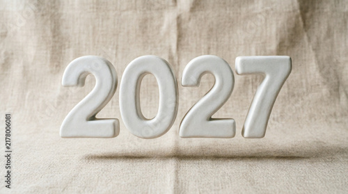 Konstfotografi White volumetric numbers year two thousand twenty seven on sackcloth fabric back