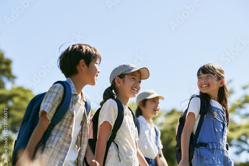 Obraz na płótnie 帽子をかぶり青空の下で遠足を楽しむ複数の日本人小学生