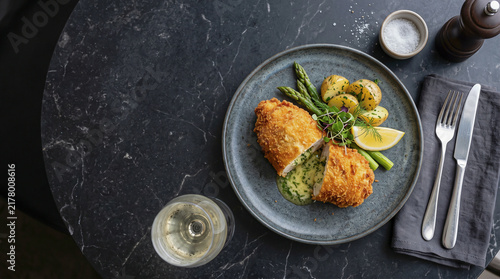 Ukrainian stew dish: Kiev chicken / breaded chicken on a table seen from above with copy space, ad image traditional East European food