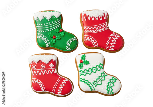 Four photorealistic, meticulously decorated gingerbread stocking cookies, thick-cut and golden-brown, viewed flat lay on a transparent backdrop, highlighting glossy red, green, and white icing.