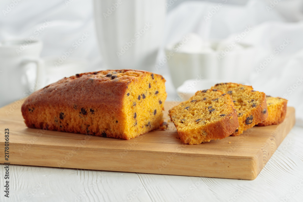 Naklejka premium Cake with chocolate pieces on a cutting board.