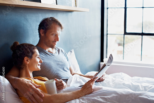 Canvastavla Couple, coffee and relax in bed with newspaper, local information and reading article in home