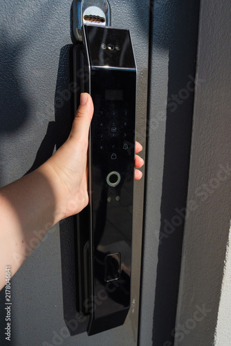 Foto Gray door opening by hand on Black Modern Smart Lock