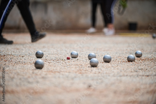 Petanque Boules and Red Cochonnet target Ball on Ground Outdoor Game