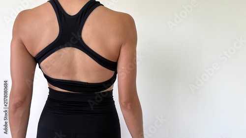Photography Close up , A Fitness woman turn back to camera show her back muscle stand poses on the left side of image , white background