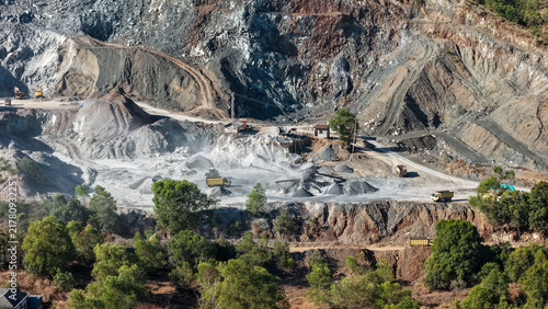 Принти на полотні Yellow dump trucks haul rocks while stone crushing equipment operates in a large