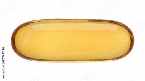 Macro view of a single yellow translucent medical gelatin capsule with medicine supplement pharmaceutical