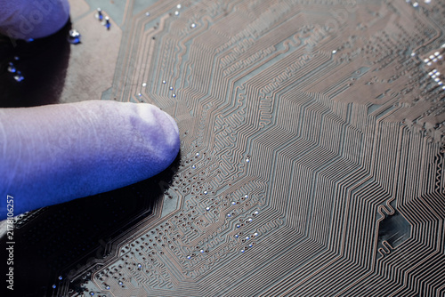 Obraz na płótnie Scientist finger in protective glove inspecting complex copper traces on an artificial intelligence printed circuit board