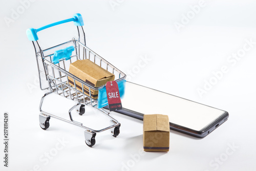 Shopping cart with smartphone, packages and sale tag for online shopping