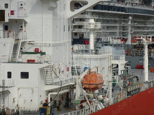 Canvastavla Detailed view of a cargo ship superstructure with lifeboat and cruise ship in th