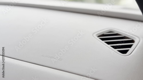 Close-up of a car dashboard with air vent and airbag area inside a clean modern vehicle interior