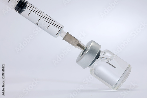 Принти на полотні Focused medical syringe drawing clear liquid vaccine dose from glass vial showin