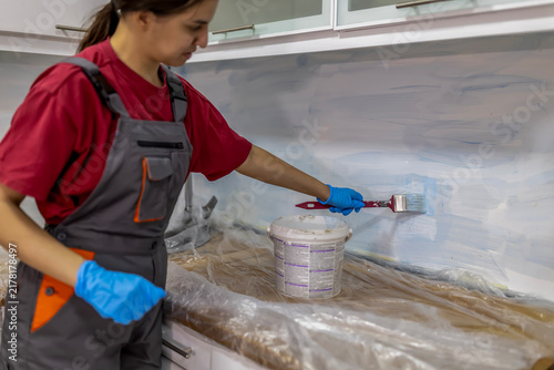 Принти на полотні Woman painting kitchen wall during home renovation project