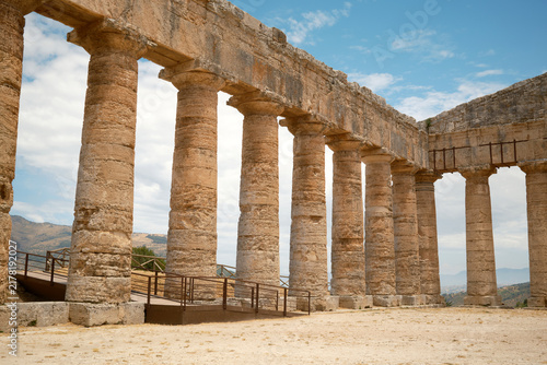 Wide-angle interior view of long Doric colonnade meeting corner architrave in Segesta, Sicily, Italy