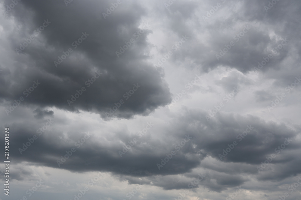 Fototapeta premium Stratocumulus Dramatic Dark Storm Clouds with Sunlight Breaking Through Over Blue Sky