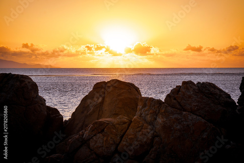 Cuadro en lienzo Aerial video along a tropical beach at dawn with golden sunrise over rocks Macka