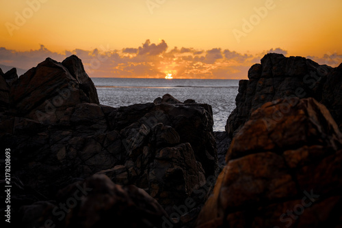 Cuadro en lienzo Aerial video along a tropical beach at dawn with golden sunrise over rocks Macka