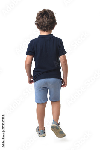back view of a boy dressed in summer clothes walking on white background (6 year old)