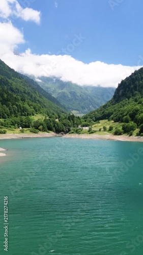 Aerial drone flying over a turquoise mountain lake.Vertical video