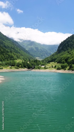 Aerial drone flying over a turquoise mountain lake.Vertical video