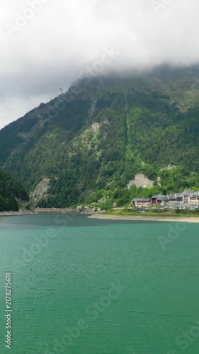 Scenic aerial flight over an alpine lake and mountain village.Vertical video