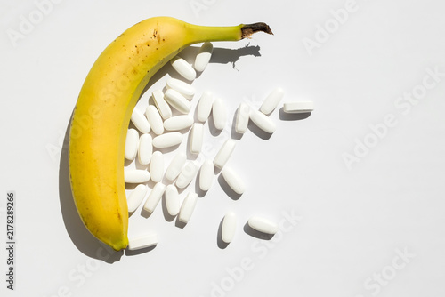 Принти на полотні Ripe banana and white pills isolated on white background for men health potency