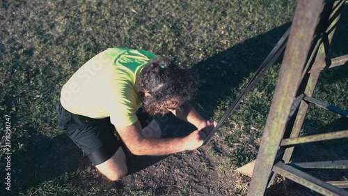 Athletic bearded man training with resistance band outdoors