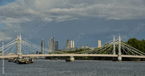 Obraz na plátně Downstream view along the River Thames from Chelsea Embankment in London, featuring river traffic, Grosvenor Railway Bridge and the modern Vauxhall skyline beneath dramatic storm clouds
