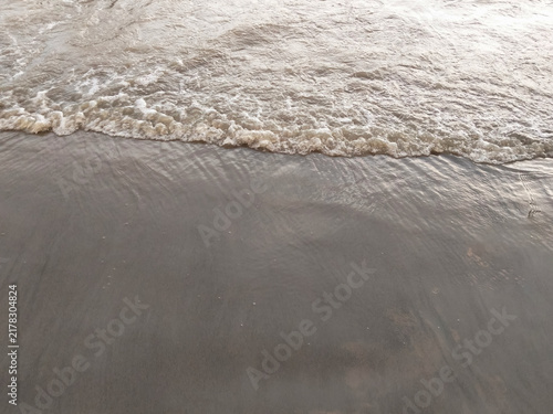 Photography Foamy white sea wave rushing towards the dark sandy shore high angle view for powerful nature background