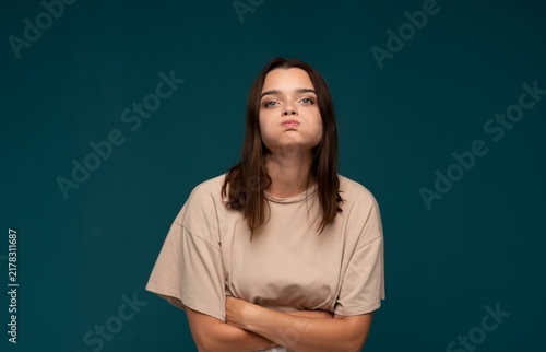 Fotografie Young woman puffing cheeks, showing frustration and impudence, feeling annoyed a