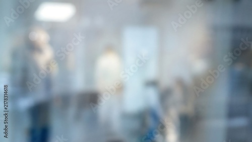 Blurred abstract image featuring indistinct shapes and light reflections on a translucent surface