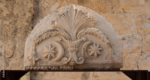 фотографія Ancient carved stone relief with floral and star motifs displayed on an outdoor