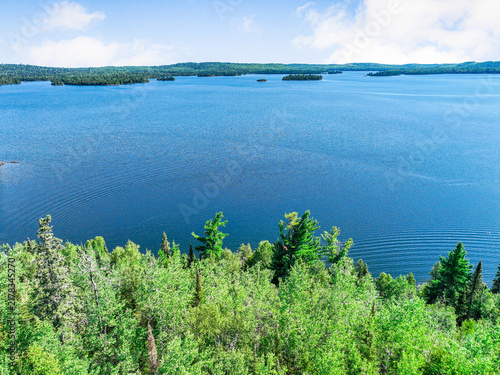 Fotografie Overhead perspective of sprawling blue lake and thick green forest canopy stretc