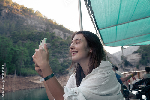 Young woman capturing Green Canyon, Turkey, during a scenic boat tour