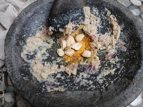 Obraz na płótnie Freshly ground herbs and spices in a traditional stone mortar and pestle (cobek