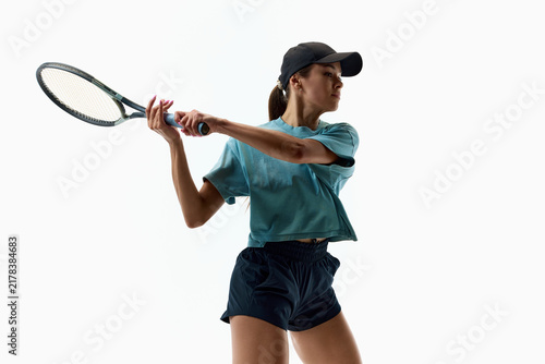 Cuadro en lienzo Female tennis player completing strong backhand in teal sportswear on white background