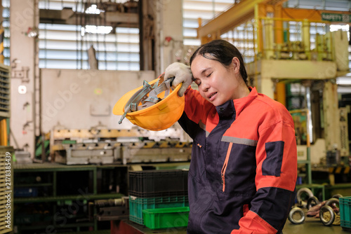 Workers stand wiping sweat from their brows in the factory