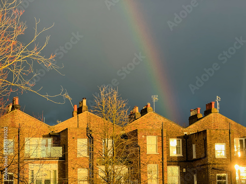 Konstfotografi A wide view of four identical brick houses in the United Kingdom positioned along the lower edge of the image beneath a dramatic dark sky