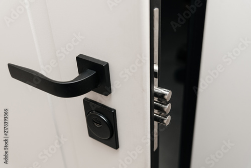 modern metal door to apartment, lock in three rods form, door slightly open, coming home concept