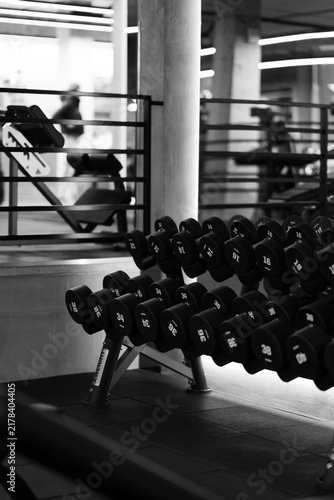 Konstfotografi Black and white dumbbell rack in a modern gym, featuring strength training equipment, industrial interior details and dramatic high contrast lighting