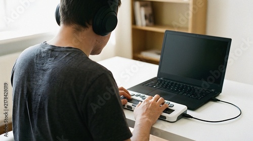 Man with visual impairment using a braille display and laptop at home