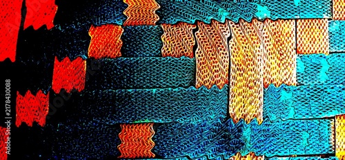Colorful woven textile texture featuring vibrant blue, turquoise, orange, red and yellow geometric patterns