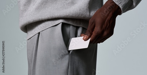 Person pulling a white card from a pocket