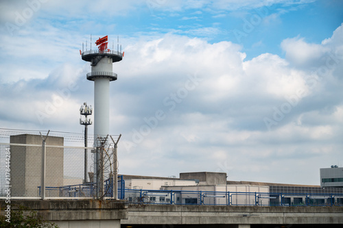 Radar tower at Frankfurt Main Airport, Germany, equipped with  distinctive orange Airport Surveillance Radar system, ASR antenna for monitoring airspace, air traffic control