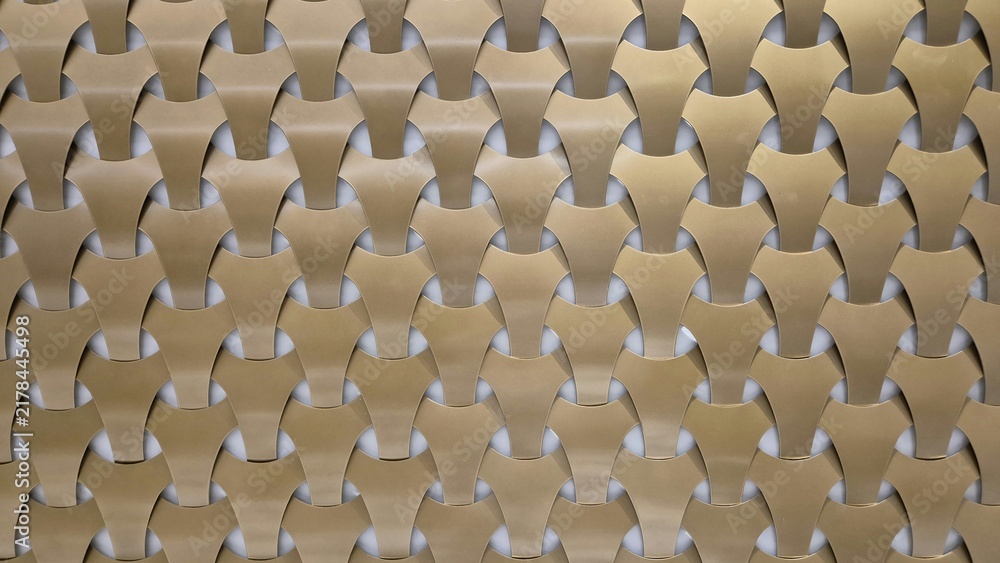 Obraz premium A repeating geometric pattern of interlocking gold and bronze metallic tiles creates a modern, textured, and three-dimensional architectural wall surface.